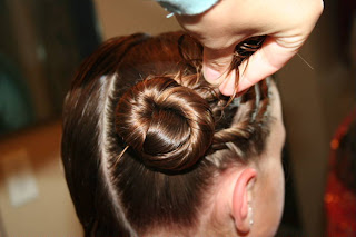 Young girl's hair being styled into "Triple Twists and Messy Buns"