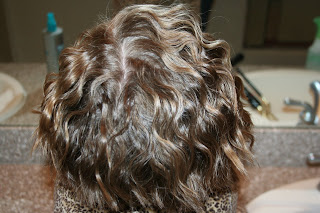 back view of young girl modeling 3-barrel curl hairstyle on her a-line bob