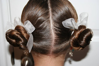 Back view of young girl modeling "Basic Twisty Buns" hairstyle