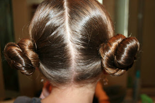 Back view of young girl modeling "Basic Twisty Buns" hairstyle