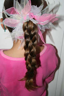 Back view of young girl modeling "Triple-Twist Ponytail' hairstyle