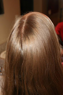 Back view of young girl's hair being styled into "Triple-Twist Ponytail' hairstyle