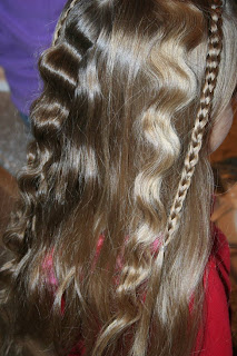 Side view of young girl's hair being styled into "Beachy Combo" hairstyle