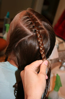 Top view of girl's hair being styled in "Criss-Cross French Braids"