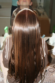 Back view of girl's hair being styled into "Zig-Zag Part"