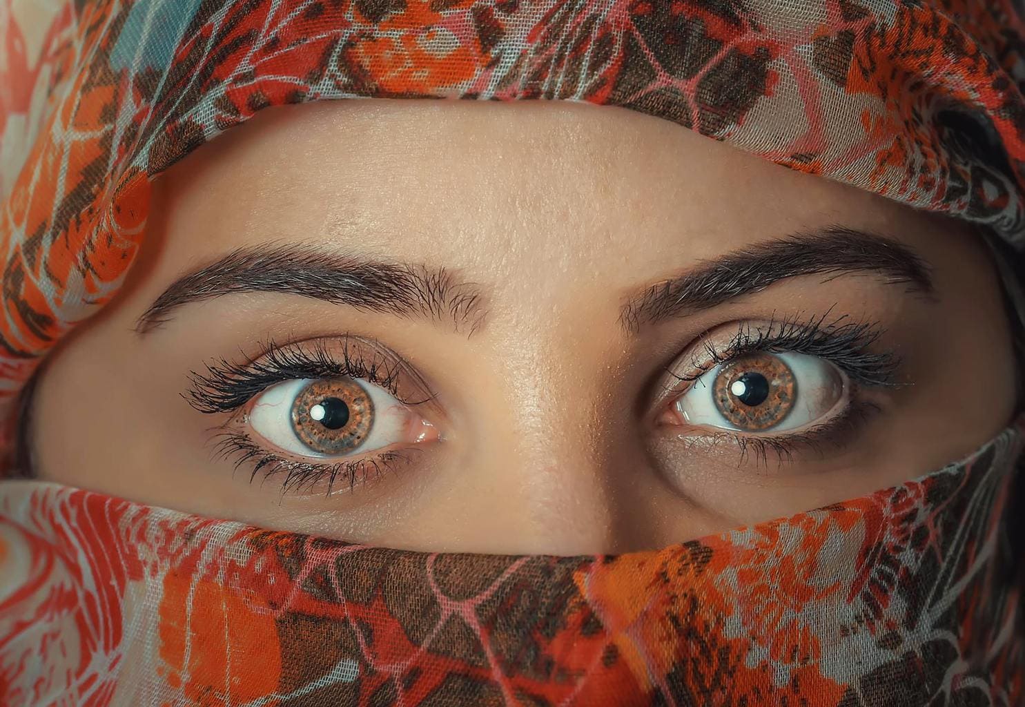 Woman looking into camera with full brows.