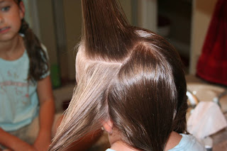 Side view of girl's hair being styled in "Criss-Cross French Braids"