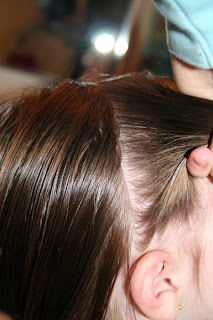 Side view of young girl's hair being styled into "Two Messy Twists on Top" Hairstyle