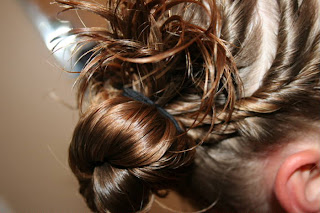 Young girl's hair being styled into "Triple Twists and Messy Buns"