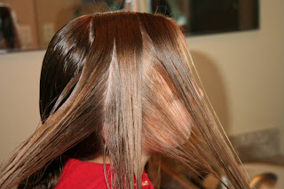 Young girl's hair being styled into "Triple Twists and Messy Buns"