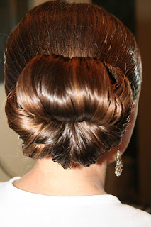 Back view of young girl's hair being styled into "Teen Hair Bun" hairstyle