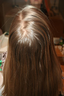 Back view of young girl's hair being styled into "Teen Slide-Up Braid" hairstyle outside