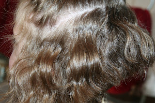 side view of young girl's hair being styled into 3-barrel curl hairstyle on her a-line bob