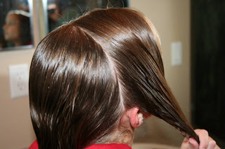 Young girl's hair being styled into "Triple Twists and Messy Buns"