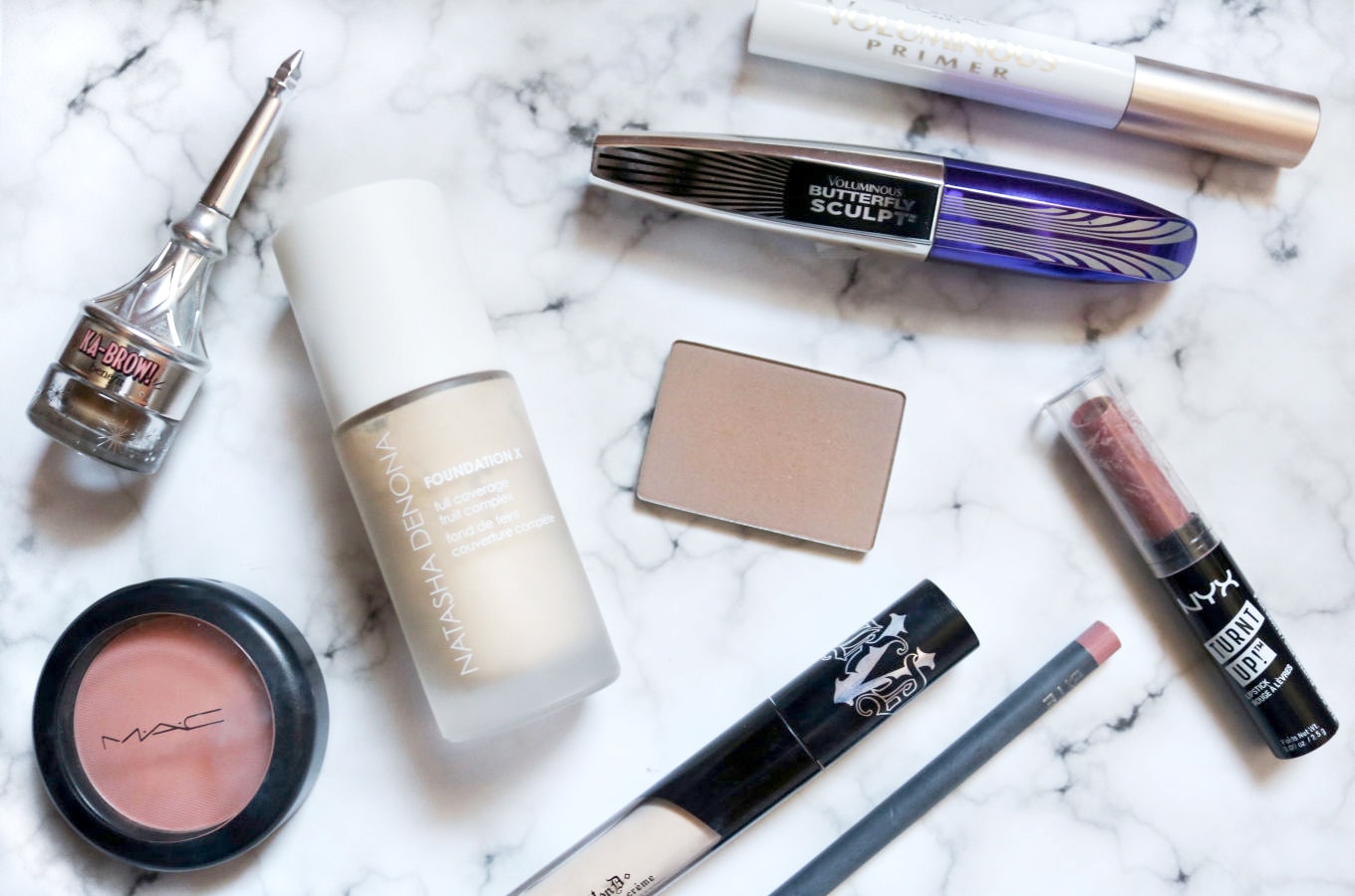 A college girl's favorite makeup products laid flat on a table