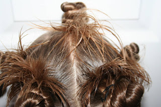 Close up Back view of young girl modeling "Holiday Twisty Buns" hairstyle