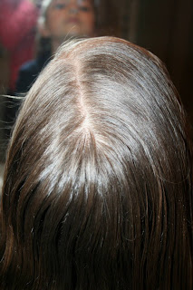 Top view of young girl's hair being styled into "bundled braids" hairstyle