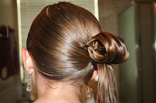 Back view of young girl's hair being styled into "Teen Hair Bun" hairstyle