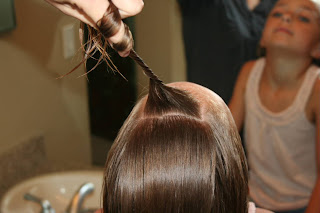 Girl's hair being styled into "Double Knot Ponytail"