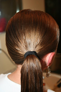 Back view of young girl's hair being styled into "Teen Hair Bun" hairstyle