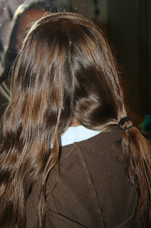 Back view of young girl's hair being styled into "Double-French Braids w/Messy Flips"