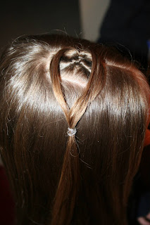 Side view of young girl having her hair styled as "teen heart" hairstyle 1