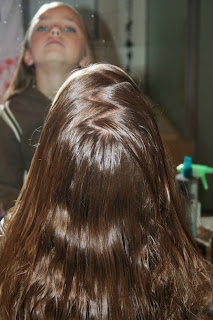 Back view of young girl's hair being styled into "Double-French Braids w/Messy Flips"