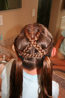 Back view of girl's hair being styled in "Criss-Cross French Braids"