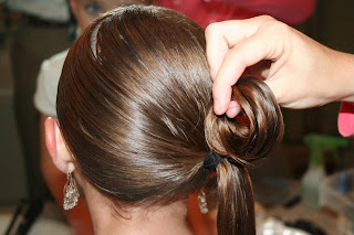 Back view of young girl's hair being styled into "Teen Hair Bun" hairstyle