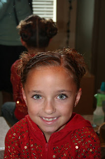 Portrait view of young girl's hair styled into "Triple Twists and Messy Buns"