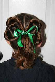 Back view of young girl modeling "Two-Leaf Clover" hairstyle styled with green ribbon hair accesory