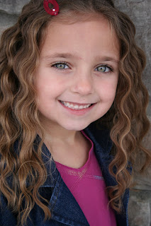 Portrait of young girl modeling 3-barrel curl hairstyle 