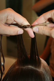 Close up view of young girl's hair being styled into "Knots into Side Ponytail" hairstyle