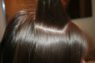 Top view of young girl's hair being styled into "Teen Slide-Up Braid" hairstyle outside