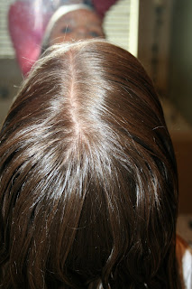 Back view of young girl's hair being styled into "4 Messy-Pigtail Twists" hairstyle