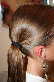 Side view of young girl's hair being styled into "Teen Hair Bun" hairstyle