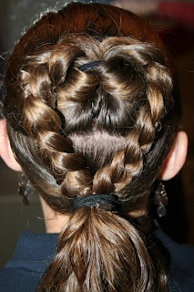 Back view of young girl's hair being styled into "Flip Braided Heart" hairstyle