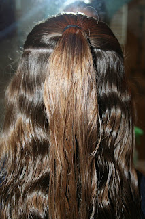 Back view of young girl's hair being styled into "Best Three-Leaf Clover" hairstyle