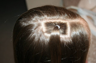 Top view of young girl having her hair styled as "teen heart" hairstyle 1