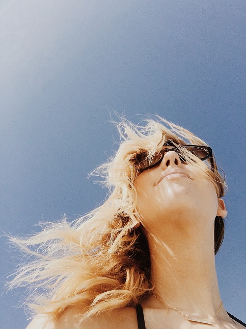 Woman in Sunglasses Looking Out at Blue Sky