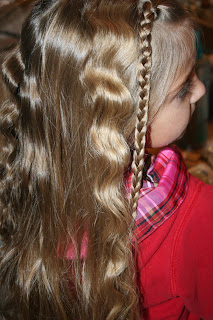 Side view of young girl's hair being styled into "Beachy Combo" hairstyle