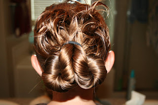 Young girl's hair being styled into "Pretzel-Twist Messy Bun"