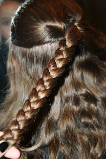 Back view of young girl's hair being styled into "Flip Braided Heart" hairstyle