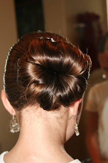 Back view of young girl's hair being styled into "Teen Hair Bun" hairstyle