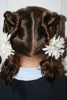 Back view of a young girl modeling “Two Hearts Twist” hairstyle