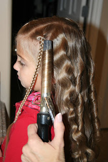 Side view of young girl's hair being styled into "Beachy Combo" hairstyle 