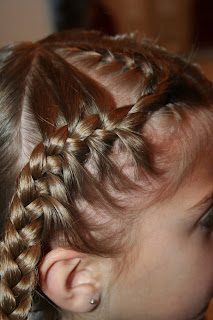 Side view of a young girl's hair being styled into “French Designer Heart” hairstyle