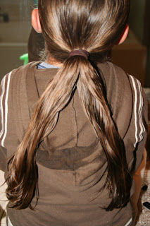 Young girl's hair being styled into "Pretzel-Twist Messy Bun"