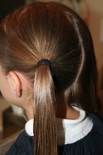 Side view of young girl's hair being styled into "Y" braid hairstyle