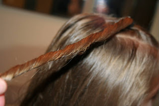 Close up view of young girl's hair being styled into "Top-Knot with Banded" Ponytail